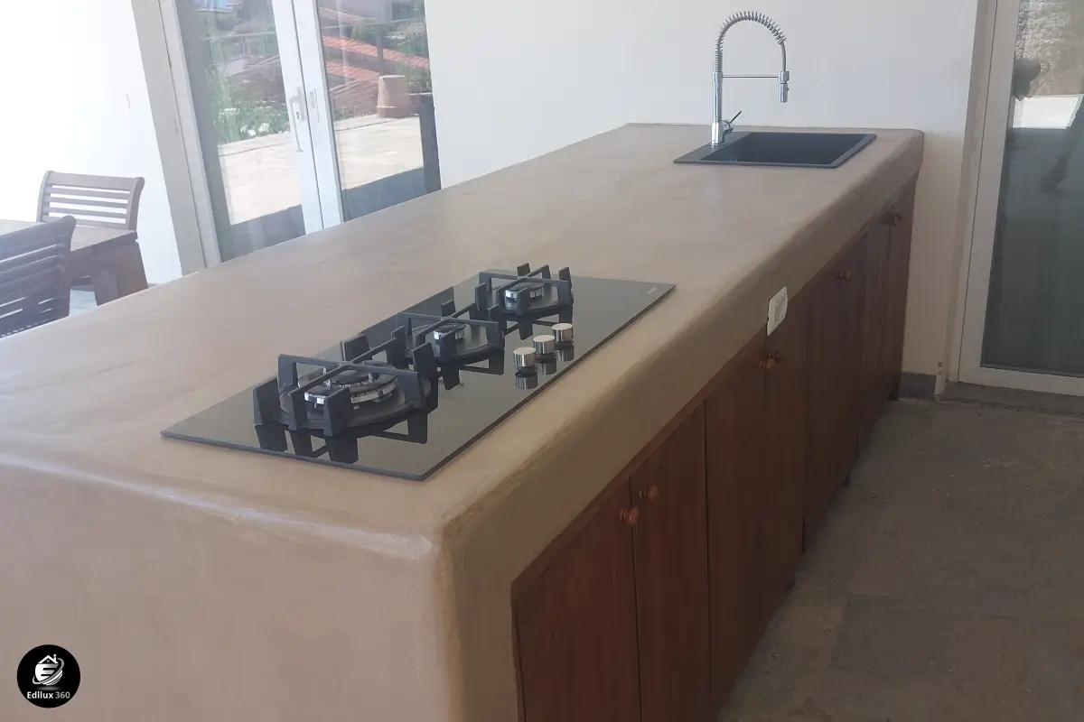 Cucina outdoor su misura con isola in cemento a vista e finiture in legno, esempio di interior design esclusivo di Edilux 360. Ristrutturazioni Grosseto