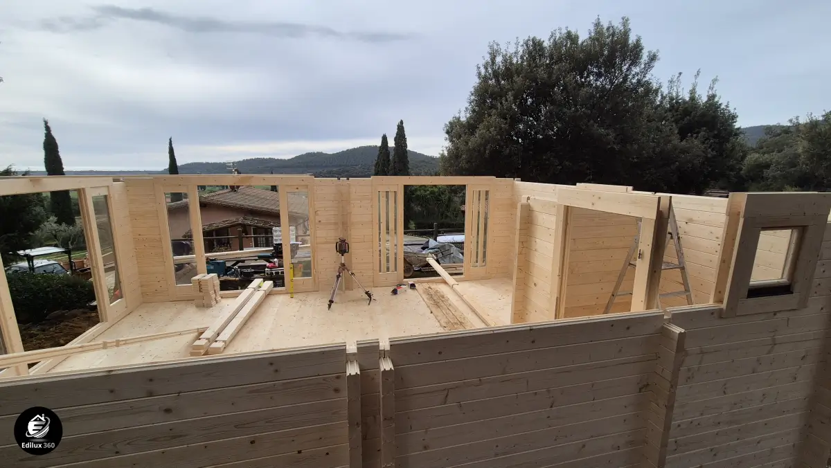 Dettaglio del montaggio delle pareti della casa in legno con travi e aperture per finestre, Scansano.