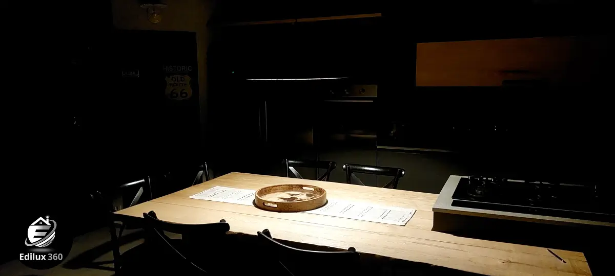 Tavolo da pranzo in legno grezzo in cucina stile industrial chic (scatto in penombra per atmosfera).